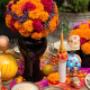 Mexican Day of the Dead decorations. Vibrant Dia de Muertos themed party decorations with papel picado bunting, ceramic skulls, paper marigold flowers, and other colourful decor.